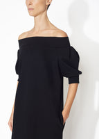 A detailed view of a black off the shoulder dress.