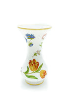 A ghost image of a white glass vase with orange painted flowers. 
