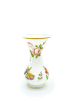 A ghost image of a white glass vase with pink painted flowers. 