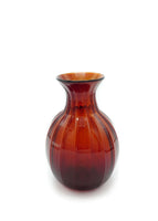 A ghost image of an amber glass vase. 