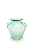 A ghost image of a green translucent vase. 